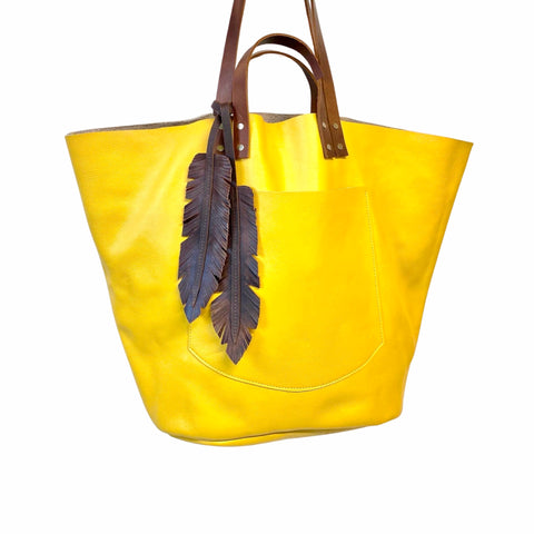 Large yellow leather tote with feather tassels