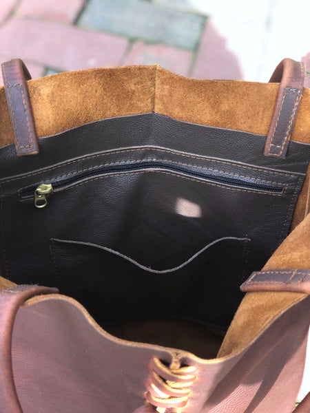 Tall brown leather tote with middle stitch and leaf tassels