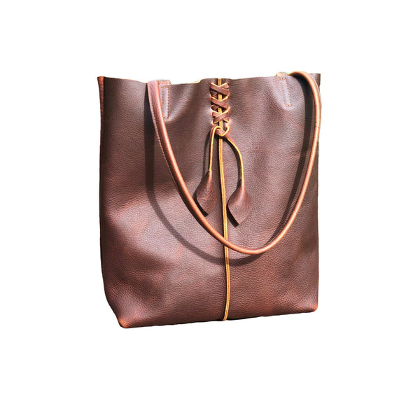 Tall brown leather tote with middle stitch and leaf tassels